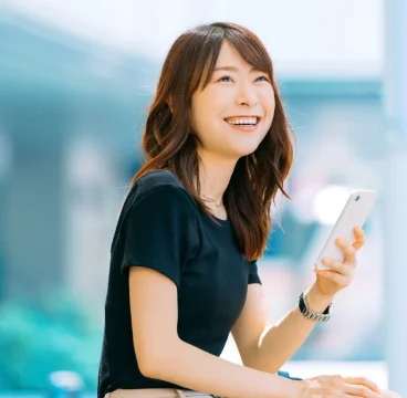 携帯電話を持って笑っている女性